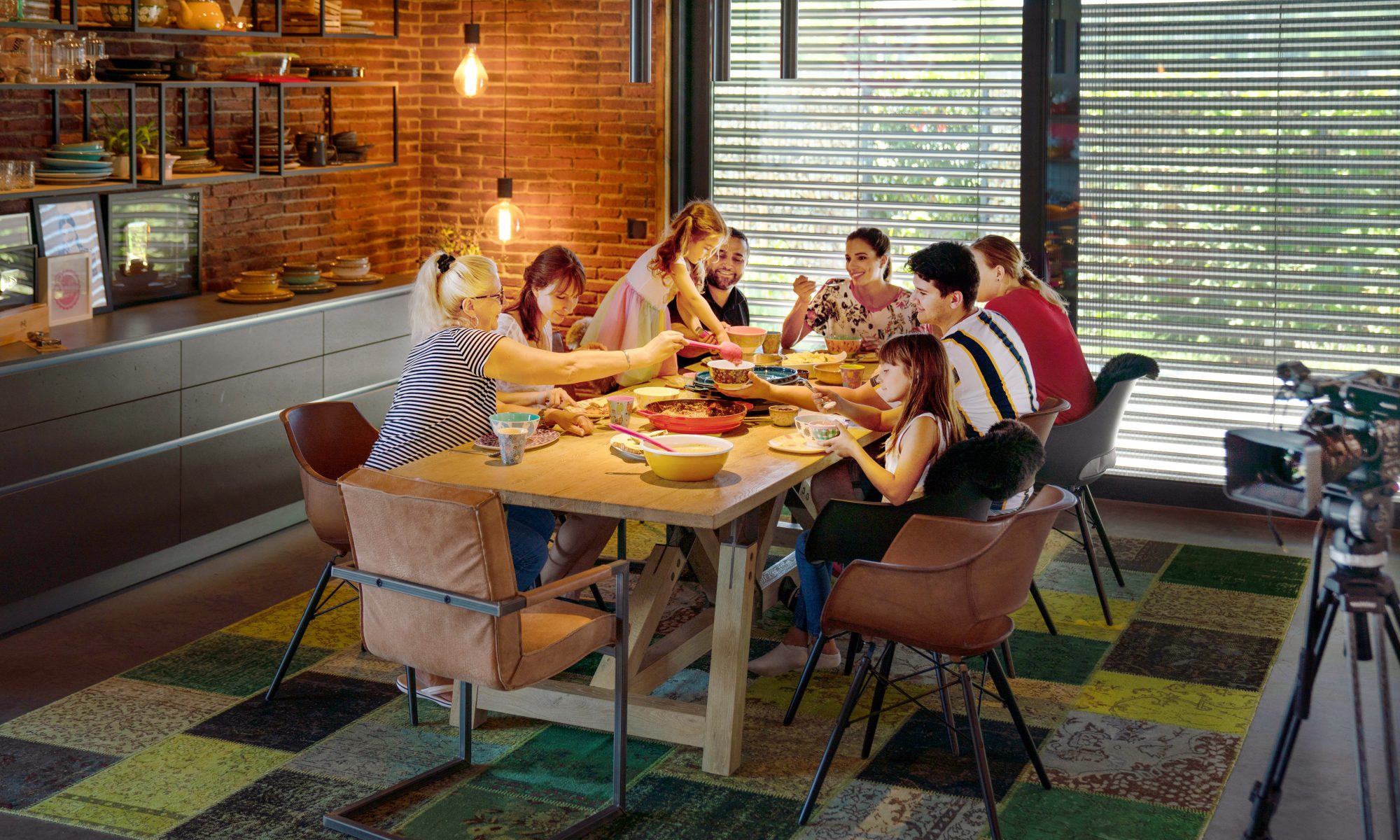 a well lit family dining table with people einjoying dinner